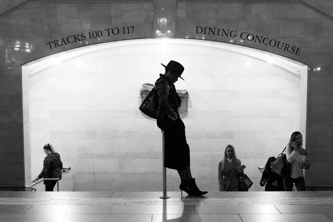 Black-and-white street photograph of a woman in Grand Central Terminal, New York
