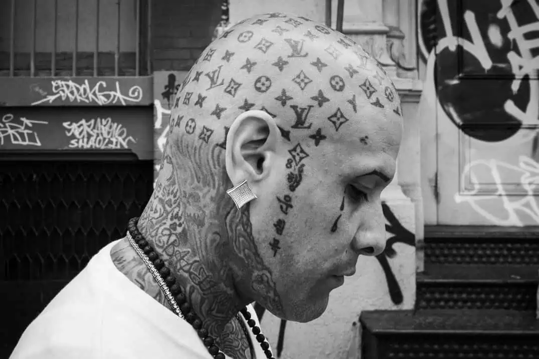 Street portrait of a man with a Louis Vuitton tattoo on his head, New York