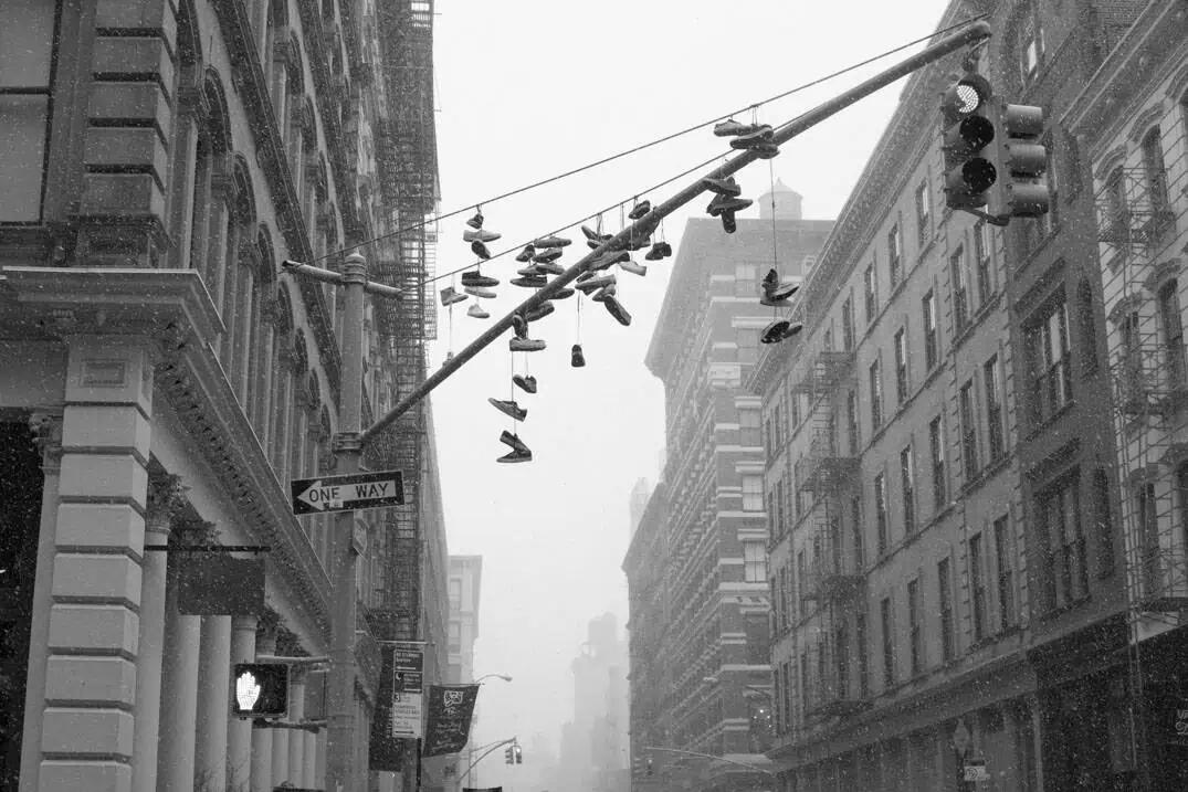 Sneakers on a lamppost in a winter snowstorm in SoHo
